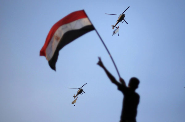 Egyptian military helicopters trailing national flags circled over Tahrir Square during a protest demanding that Egyptian President Mohamed Mursi resign in Cairo July 1, 2013. Egypt's Mursi rebuffs army ultimatum