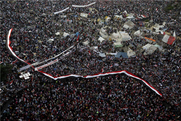 Protesters who are against deposed Egyptian President Mohamed Morsi shout solgans as they hold Egypt flags at Tahrir square in Cairo, July 7, 2013. Huge crowds rally in Egypt, political talks stalled