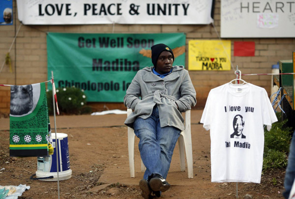 A street vendor sells t-shirts and fabric outside the hospital where ailing former President Nelson Mandela is being treated in Pretoria, July 10, 2013. Mandela 'responding to treatment'