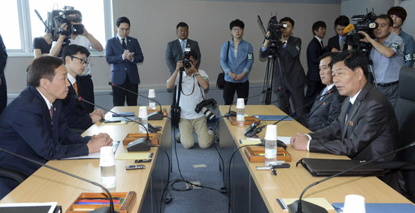 Head of the ROK's working-level delegation, Kim Ki-woong (front, L), talks with his DPRK counterpart Park Chol-su (front, R) during their talks at Kaesong Industrial District Management Committee in Kaesong July 15, 2013. ROK, DPRK open 3rd round of talks