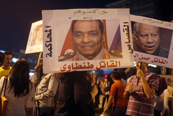 Activists from a group called 'Third Square', which promotes a middle way in the rift between the Muslim Brotherhood and supporters of the army's overthrow of Egyptian President Mohamed Mursi, carry posters of key former army figures as they gather to oppose both parties at Sphinx Square in Cairo July 30, 2013. Egypt's rulers to move against Brotherhood vigils